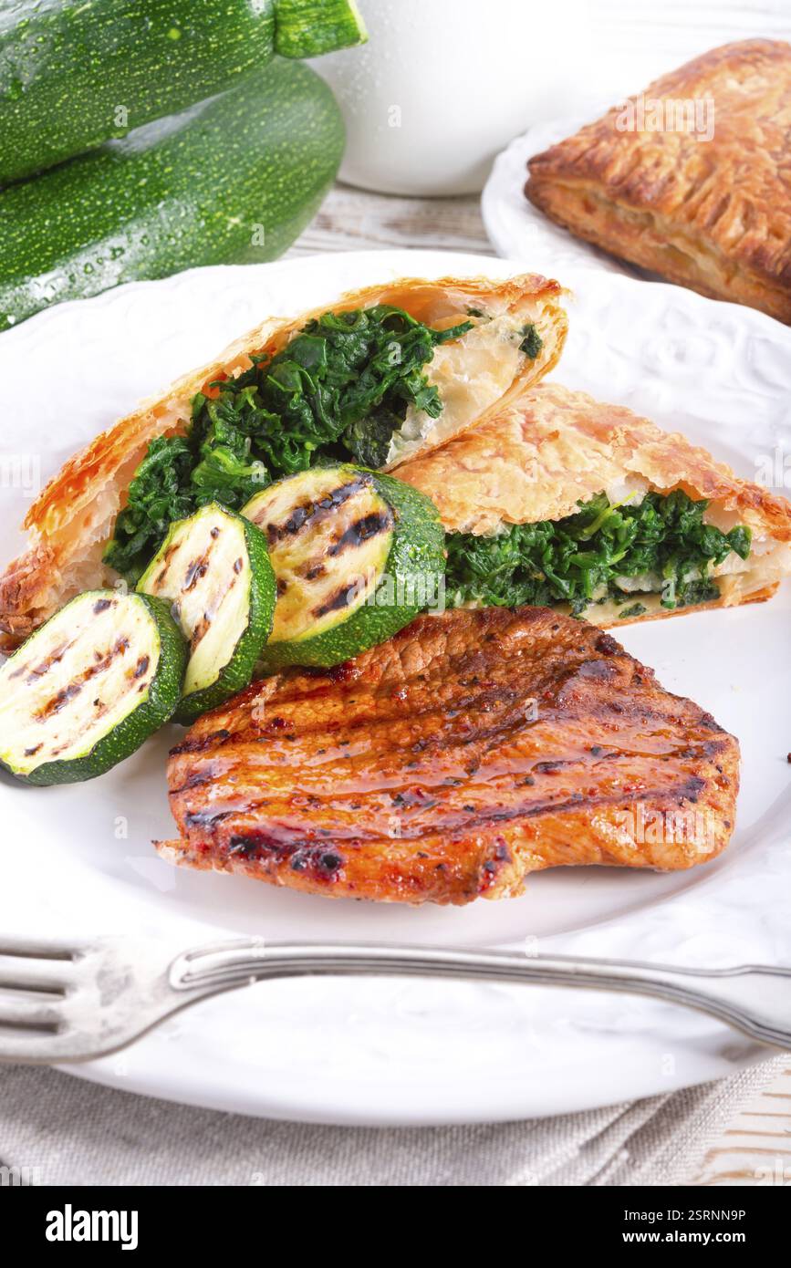 Bistecche alla griglia con sacchetto di pasta sfoglia e zucchine Foto Stock