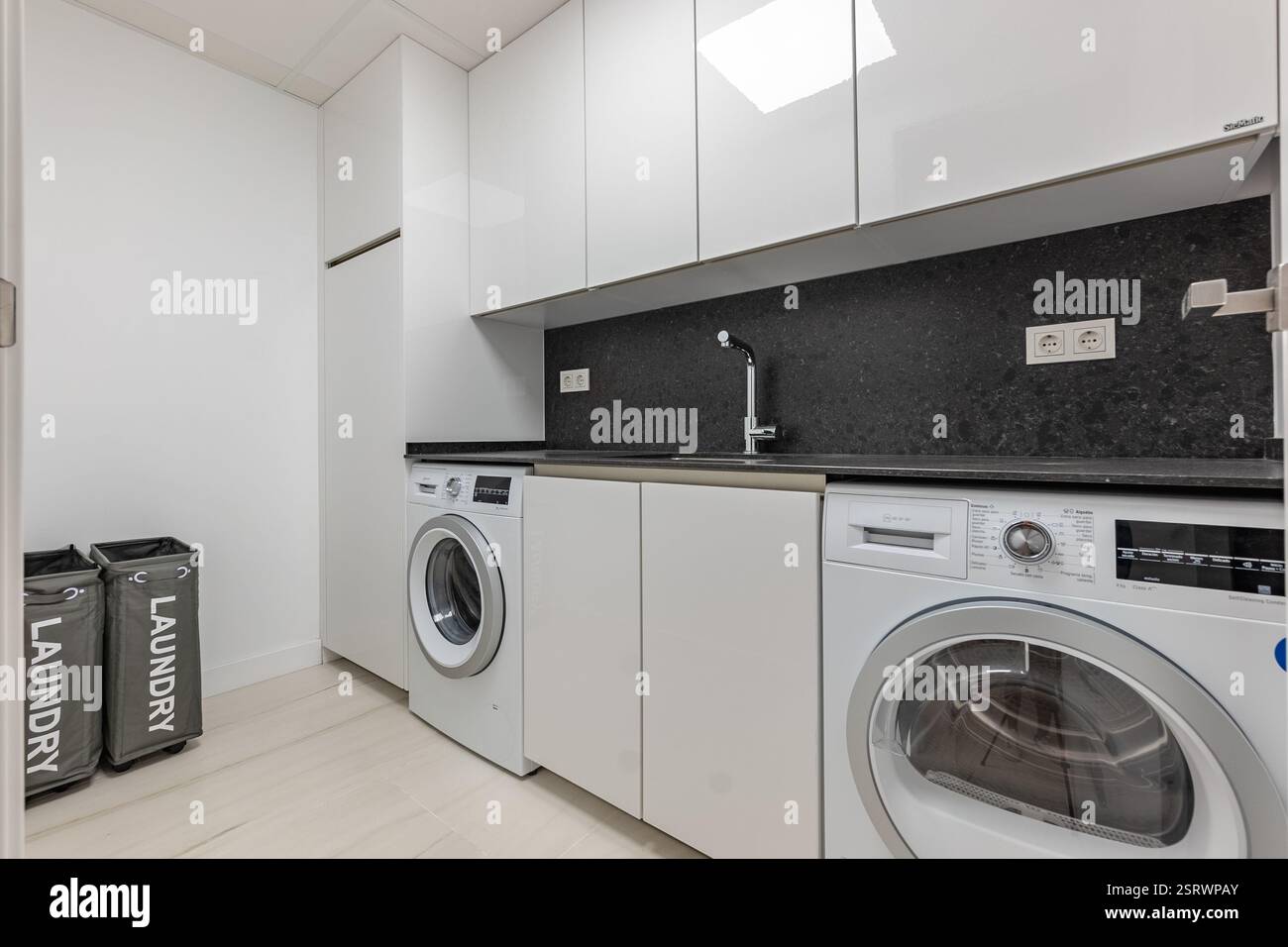 un'immagine di un'area lavanderia con lavatrice e asciugatrice in appartamenti di lusso Foto Stock