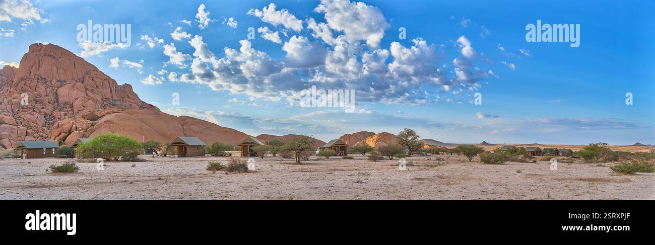 Piccola montagna Spitzkoppe con cabine da campeggio dietro l'alba, una vista del deserto a sud, Namibia, Africa. Foto Stock