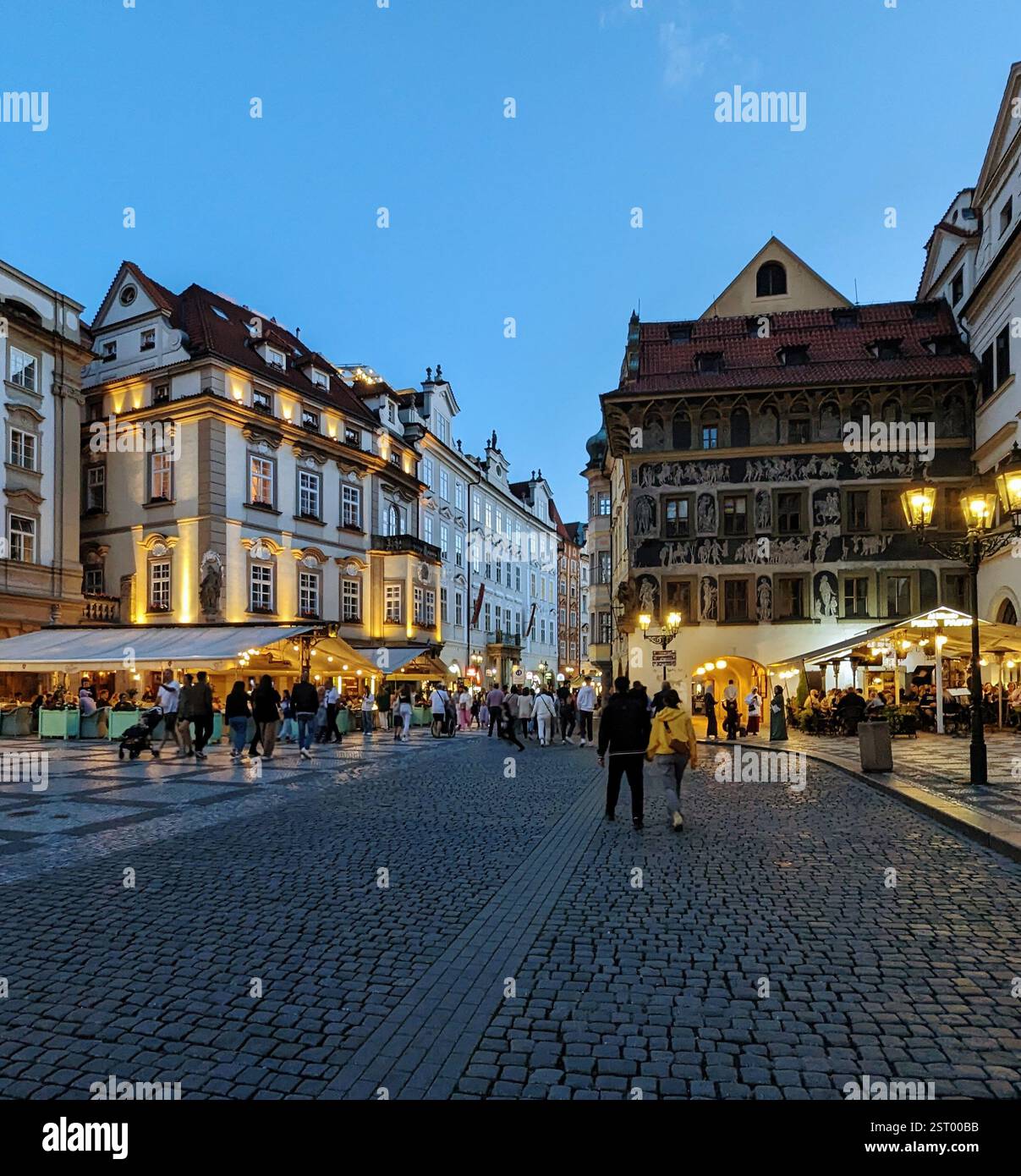 Le luci serali e il fascino storico riempiono la Piazza della città Vecchia di Praga, dove le strade acciottolate, i vivaci caffè e la splendida architettura prendono vita. - Immagine stock catturata con smartphone