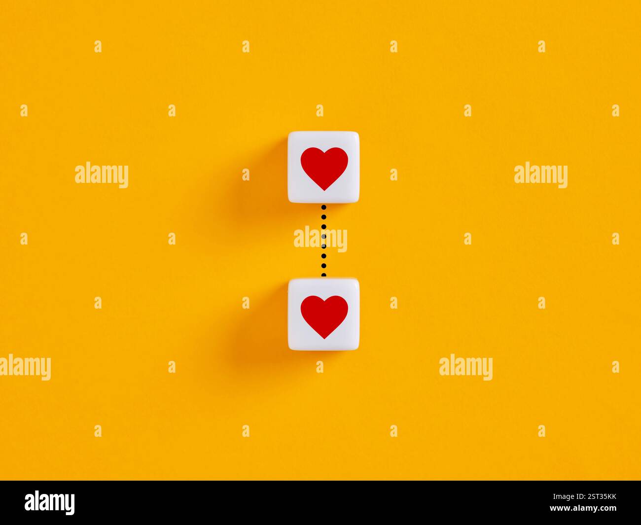 Legame d'amore, relazione romantica e Unione. Unione, due cubi bianchi con simboli di cuori rossi collegati da una linea. Foto Stock