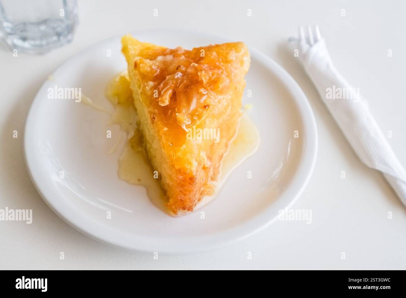 Un pezzo di torta dolce greca galaktoboureko su un piatto bianco Foto Stock