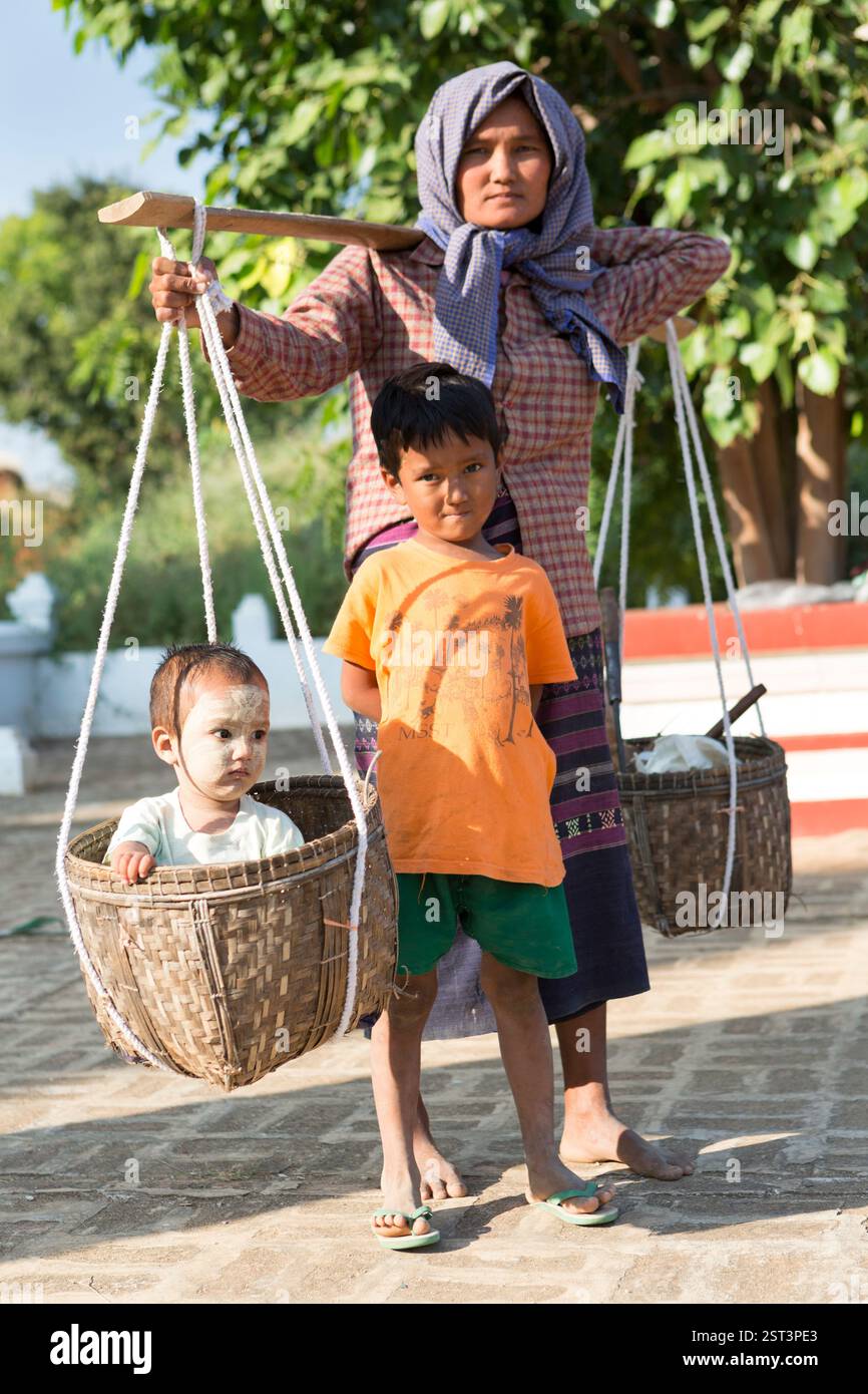 Myanmar, Bagan, donna del posto con un bambino in portatore. Foto Stock