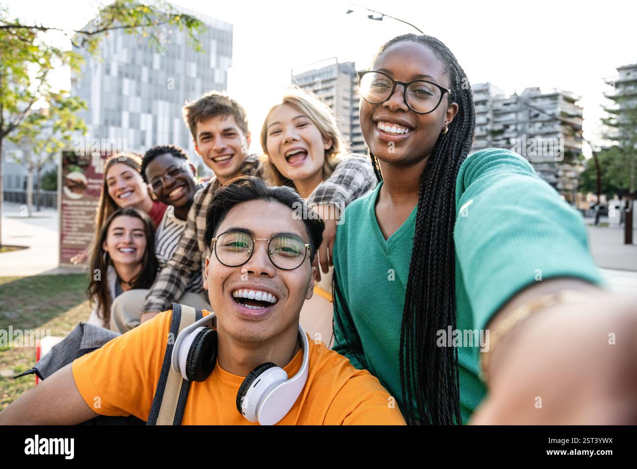 Un gruppo variegato di amici che si godono una giornata di sole all'aperto insieme e si divertono Foto Stock