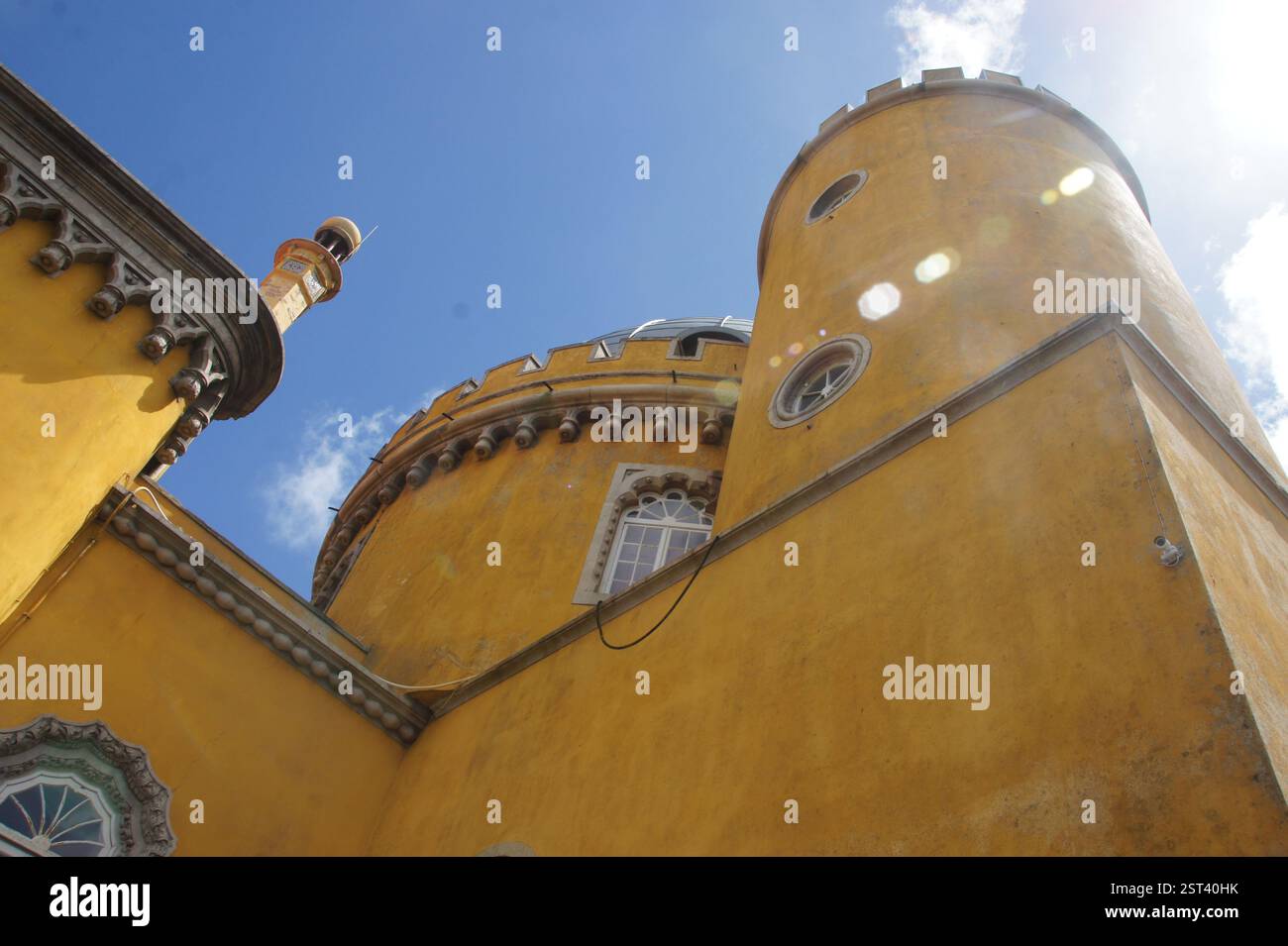 Palácio da pena, Sintra, Portogallo. Facciata gialla vibrante con dettagli intricati su un cielo azzurro. Un castello da favola arroccato sulle colline portoghesi. Foto Stock