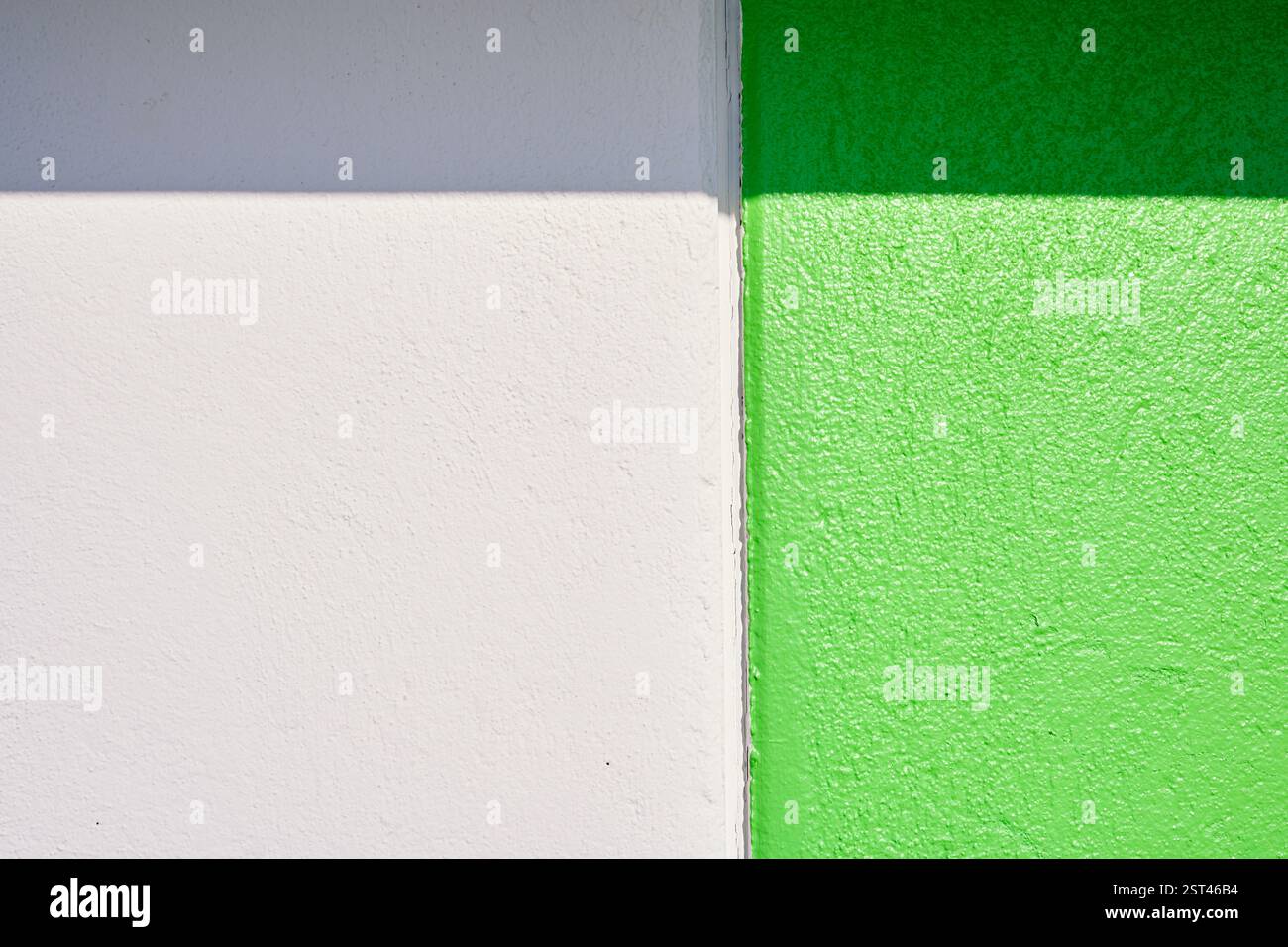 Luce solare che crea ombre su pareti verdi e bianche Foto Stock