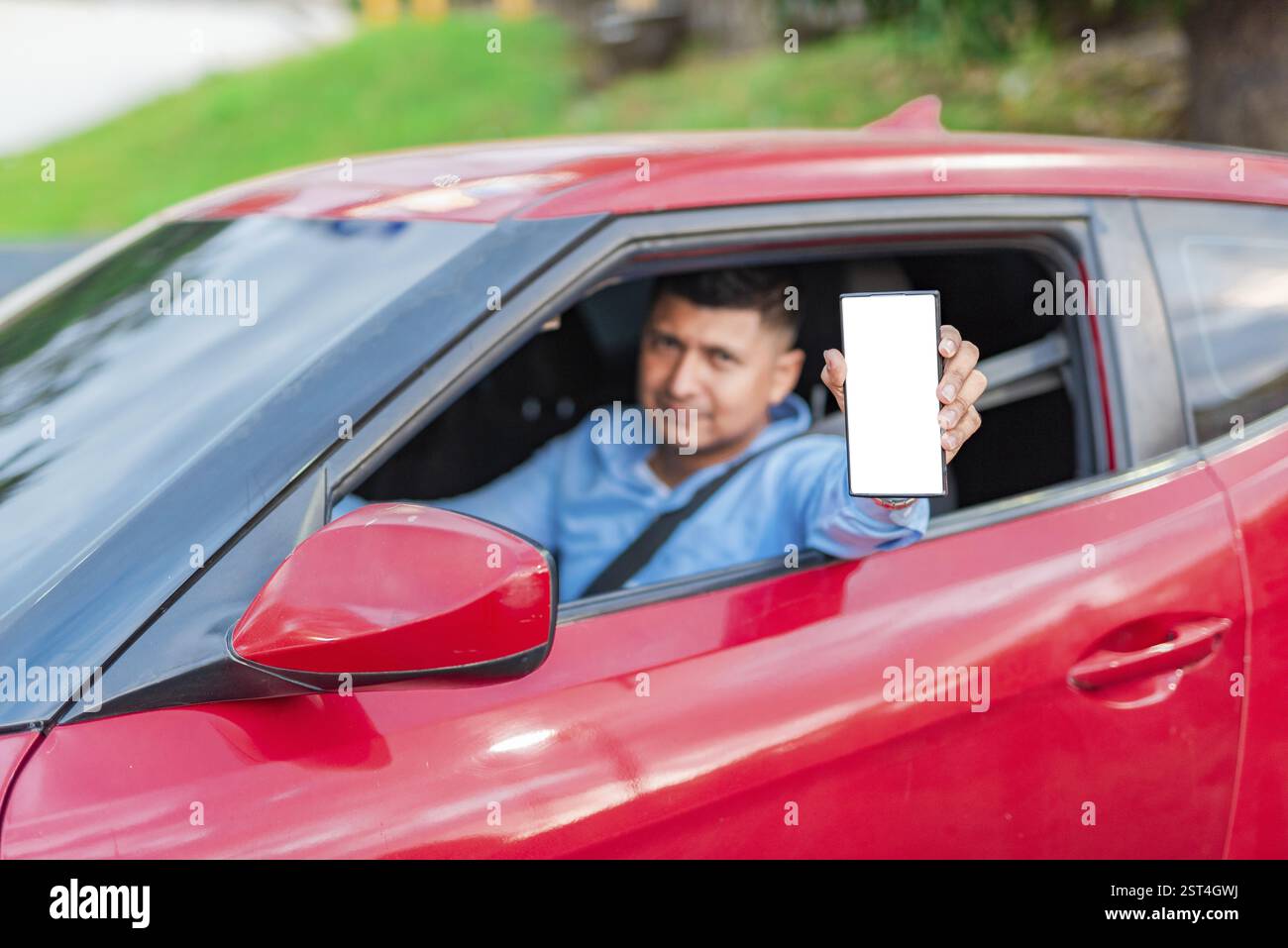 Happy driver che mostra la schermata del telefono cellulare. Driver che mostra lo schermo vuoto del telefono cellulare all'esterno Foto Stock