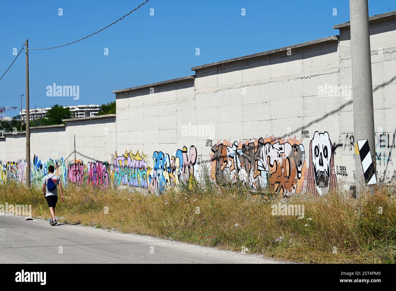 L'uomo oltrepassa il muro con dei graffiti Foto Stock