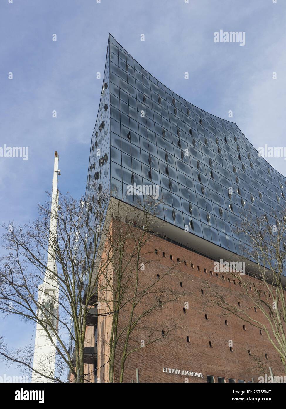 L'Elbphilharmonie con la sua suggestiva facciata in vetro, circondata da un cielo nuvoloso, amburgo, germania Foto Stock