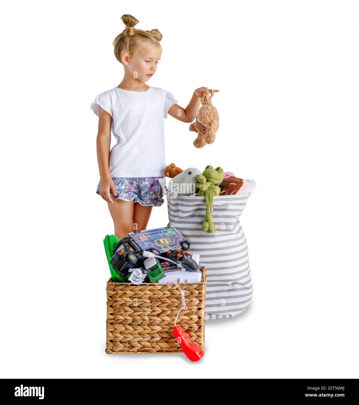 Una ragazza che ordina i giocattoli in cesti, concetto di riciclaggio, isolata su sfondo bianco, tema ecologico Foto Stock