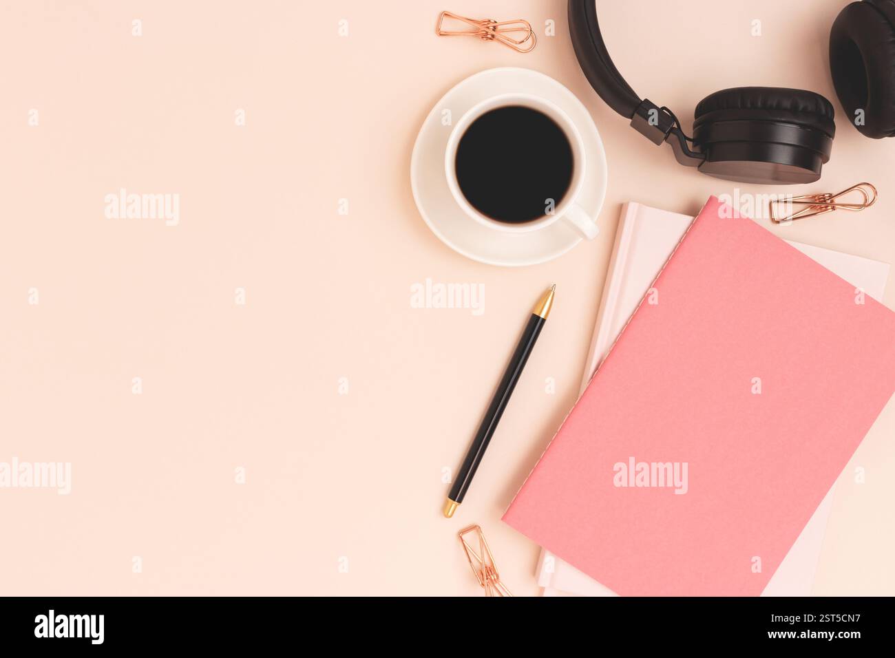 Copybook, tazza di caffè e cuffie wireless su sfondo beige. Posiziona per testo. Foto Stock