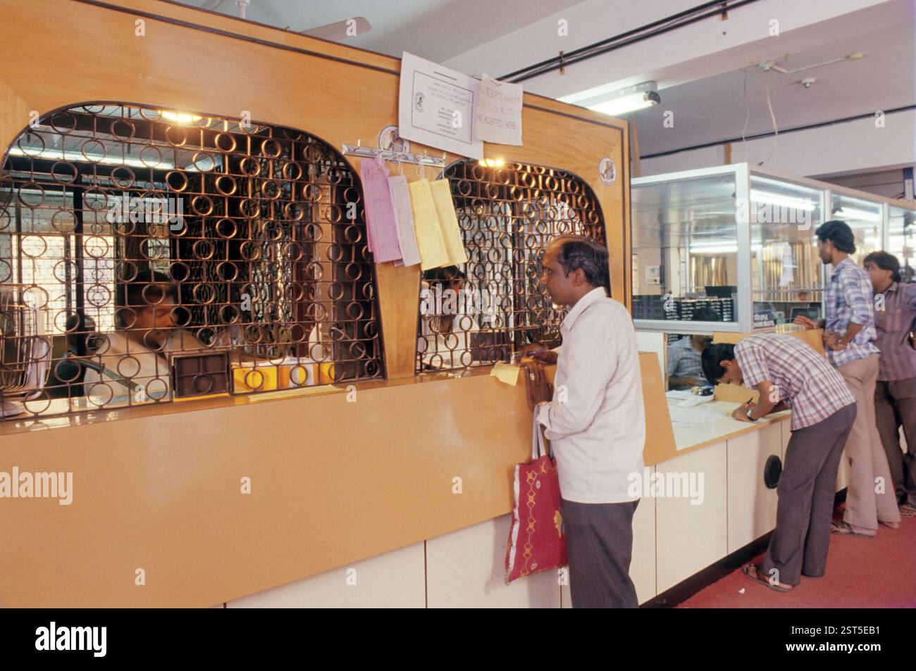 Uomo in piedi davanti al bancone, industria bancaria, Bangalore, Karnataka, India, Asia Foto Stock