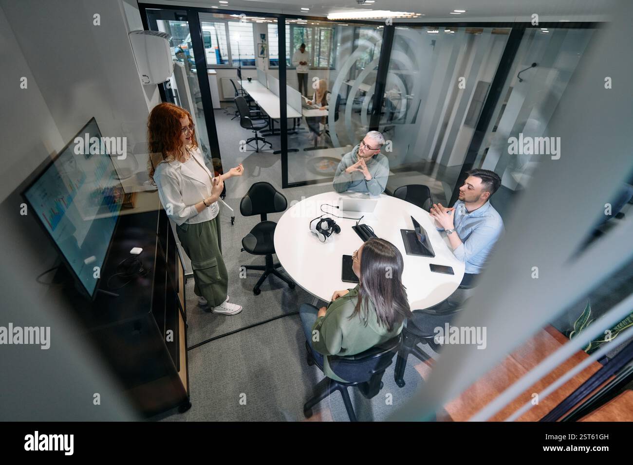 Un gruppo eterogeneo di uomini d'affari collabora e testa una nuova tecnologia di realtà virtuale, indossando occhiali virtuali, mostrando innovazione e creatività Foto Stock