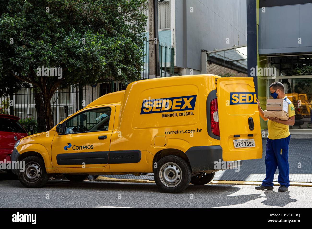 San Paolo, Brasile, 24 - 2021 aprile: Furgone logistico dall'ufficio postale brasiliano. Il lavoratore consegna la posta sedex con maschera anti covid, Brasile. Il brasiliano va Foto Stock