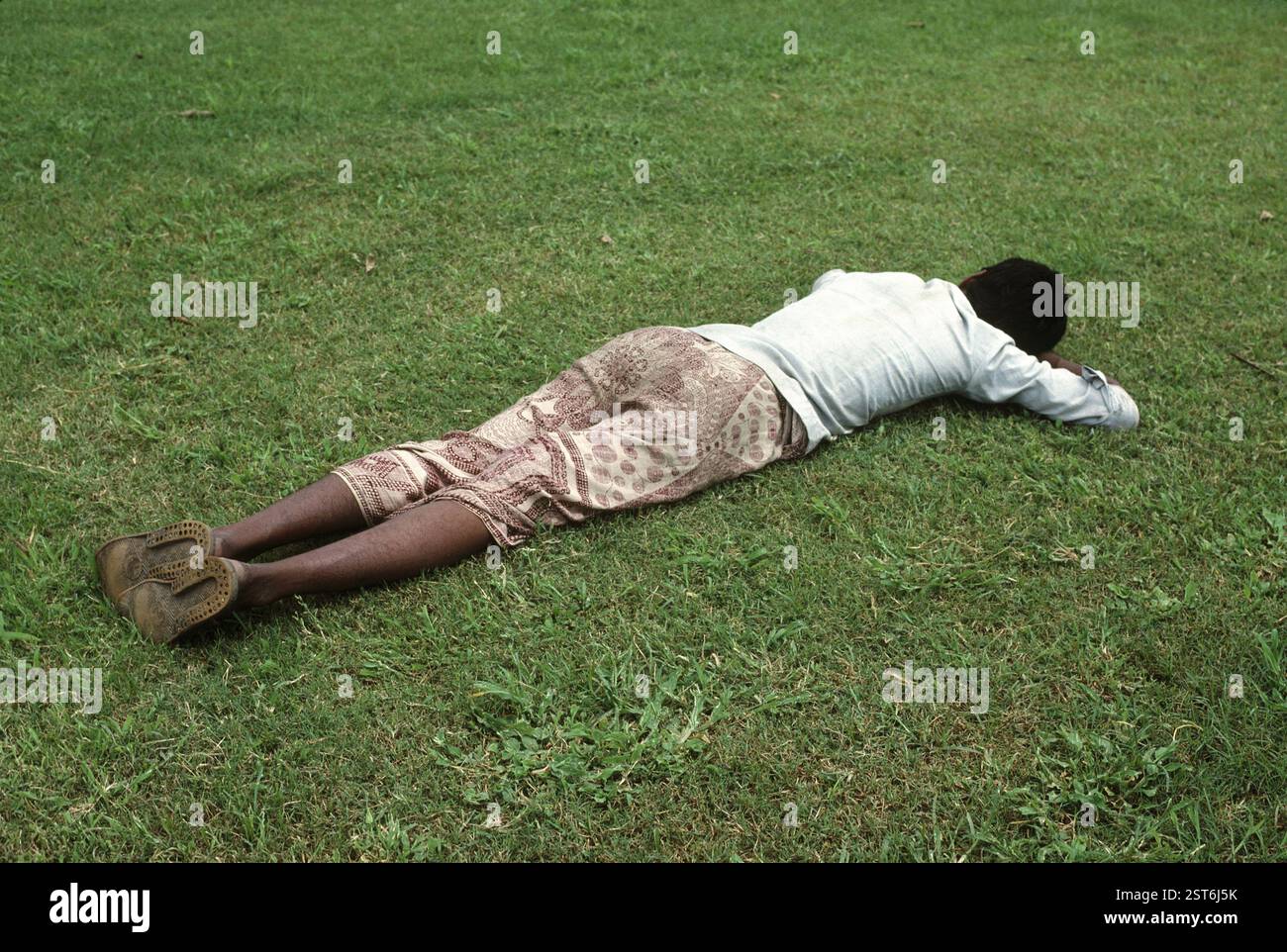 Uomo che dorme sull'erba verde, India, Asia Foto Stock