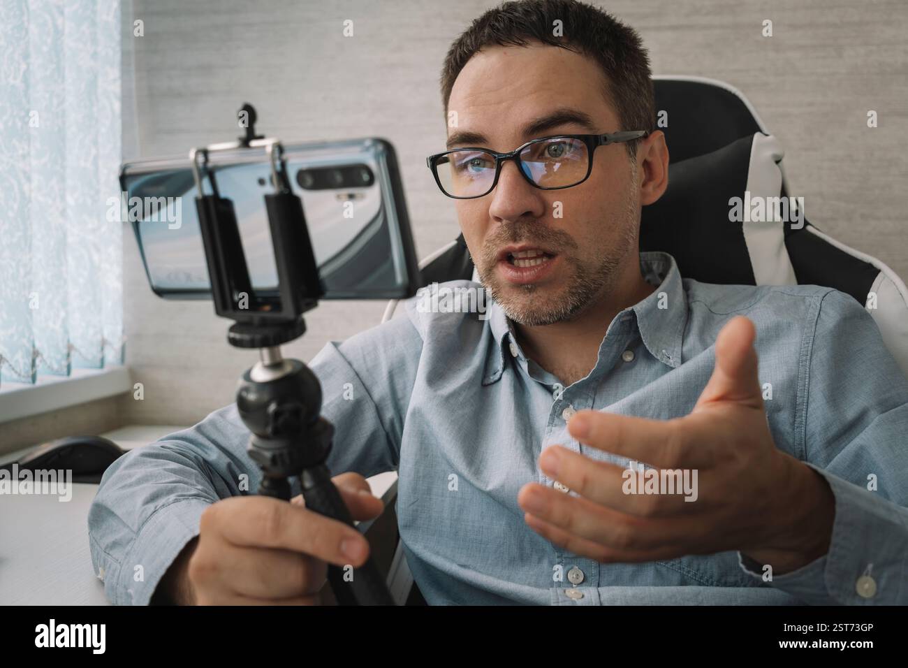 Bell'uomo che fa il video blog. Focus su smartphone. Giovane blog video spara contenuti per il suo video blog su un social network. Trasmissione in tempo reale tramite Foto Stock