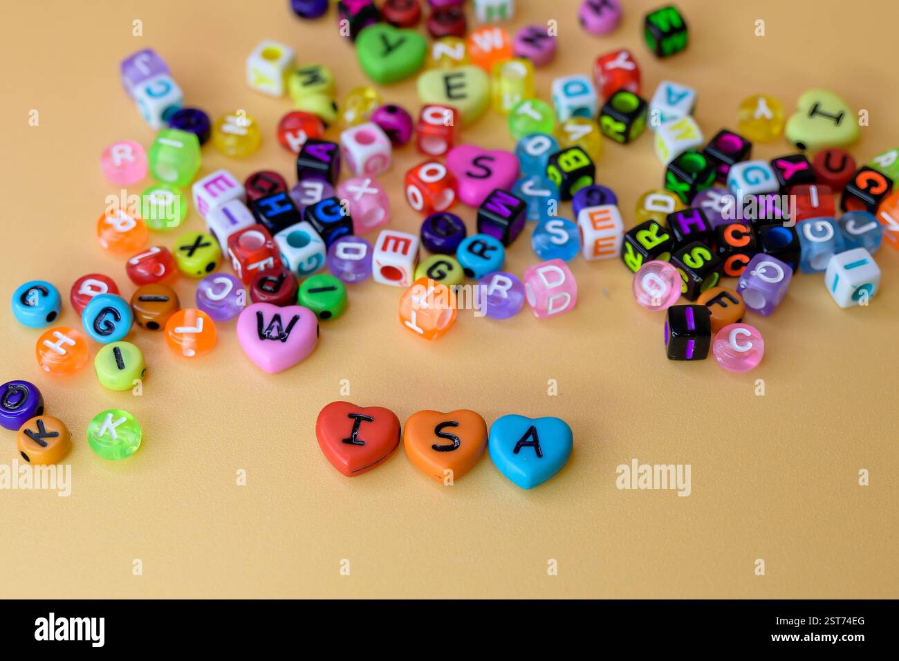 Colorful Hearts with Letters of ISA, i S A, conto di risparmio individuale su sfondo beige circondato da piccole perline decorative, risparmi esentasse Foto Stock