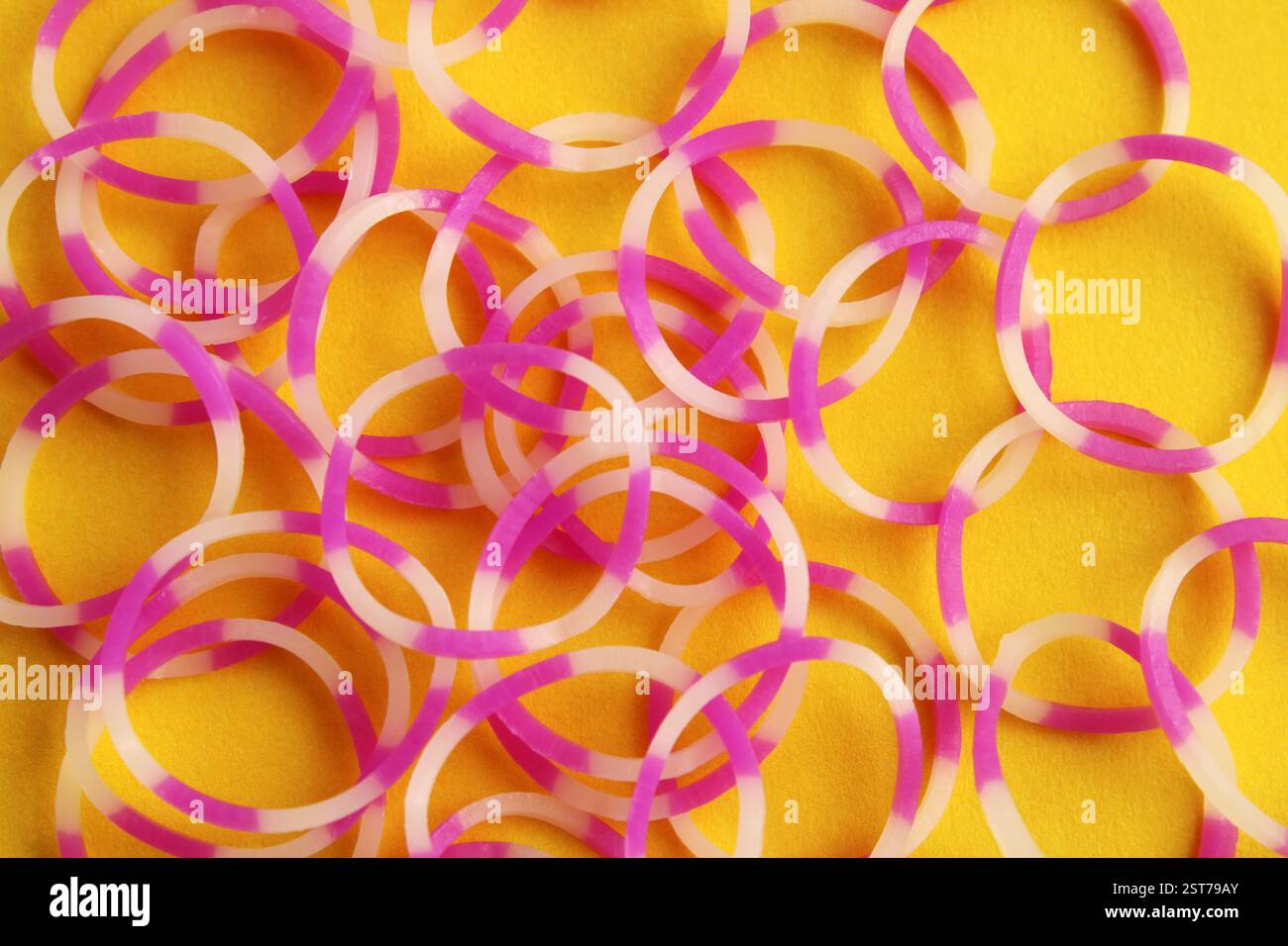 Fasce elastiche con combinazione rosa e bianco su sfondo giallo Foto Stock