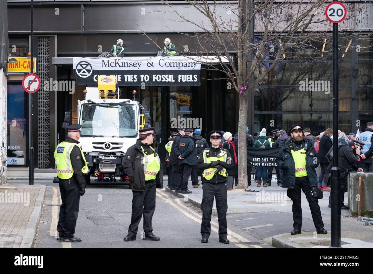Londra, Regno Unito. 17 febbraio 2025. La polizia si prepara a rimuovere gli attivisti per il clima dalla ribellione dell'estinzione che occupa il tetto d'ingresso alla McKinsey & Company, durante una protesta che invita i consulenti di gestione a "tagliare i legami" con l'industria dei combustibili fossili responsabile del riscaldamento globale. Crediti: Ron Fassbender/Alamy Live News Foto Stock