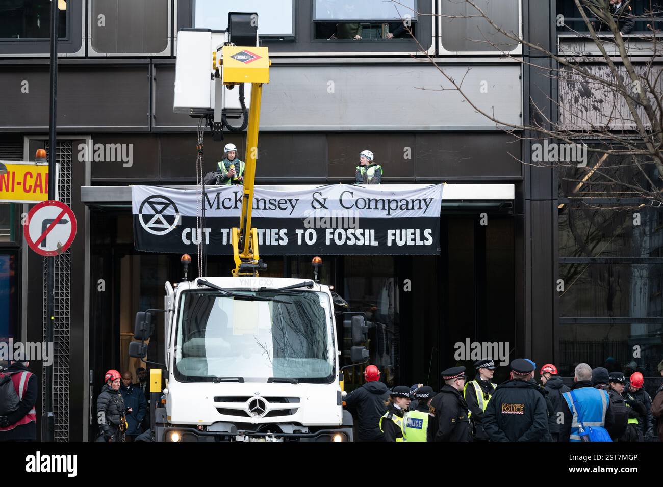 Londra, Regno Unito. 17 febbraio 2025. La polizia si prepara a rimuovere gli attivisti per il clima dalla ribellione dell'estinzione che occupa il tetto d'ingresso alla McKinsey & Company, durante una protesta che invita i consulenti di gestione a "tagliare i legami" con l'industria dei combustibili fossili responsabile del riscaldamento globale. Crediti: Ron Fassbender/Alamy Live News Foto Stock