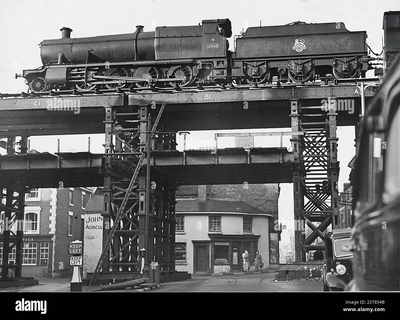 Locomotiva a vapore della British Railways che attraversa il ponte sotto autorizzazione a Shifnal il 6 novembre 1953 Foto Stock