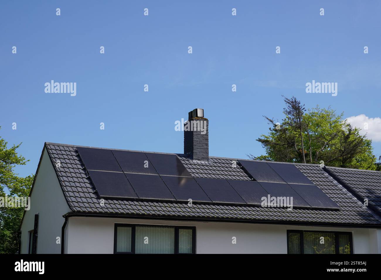 Pannelli a energia solare sul tetto di un edificio residenziale. Celle fotovoltaiche. Energie rinnovabili alternative per le abitazioni Foto Stock