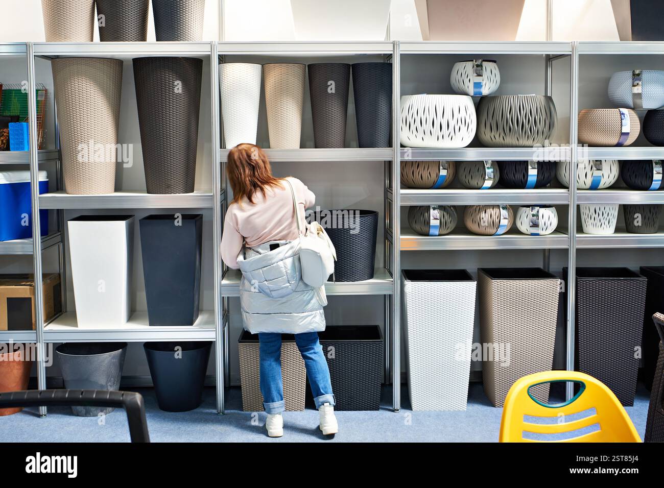 La donna che acquista sceglie i contenitori di plastica nel negozio di articoli per la casa Foto Stock