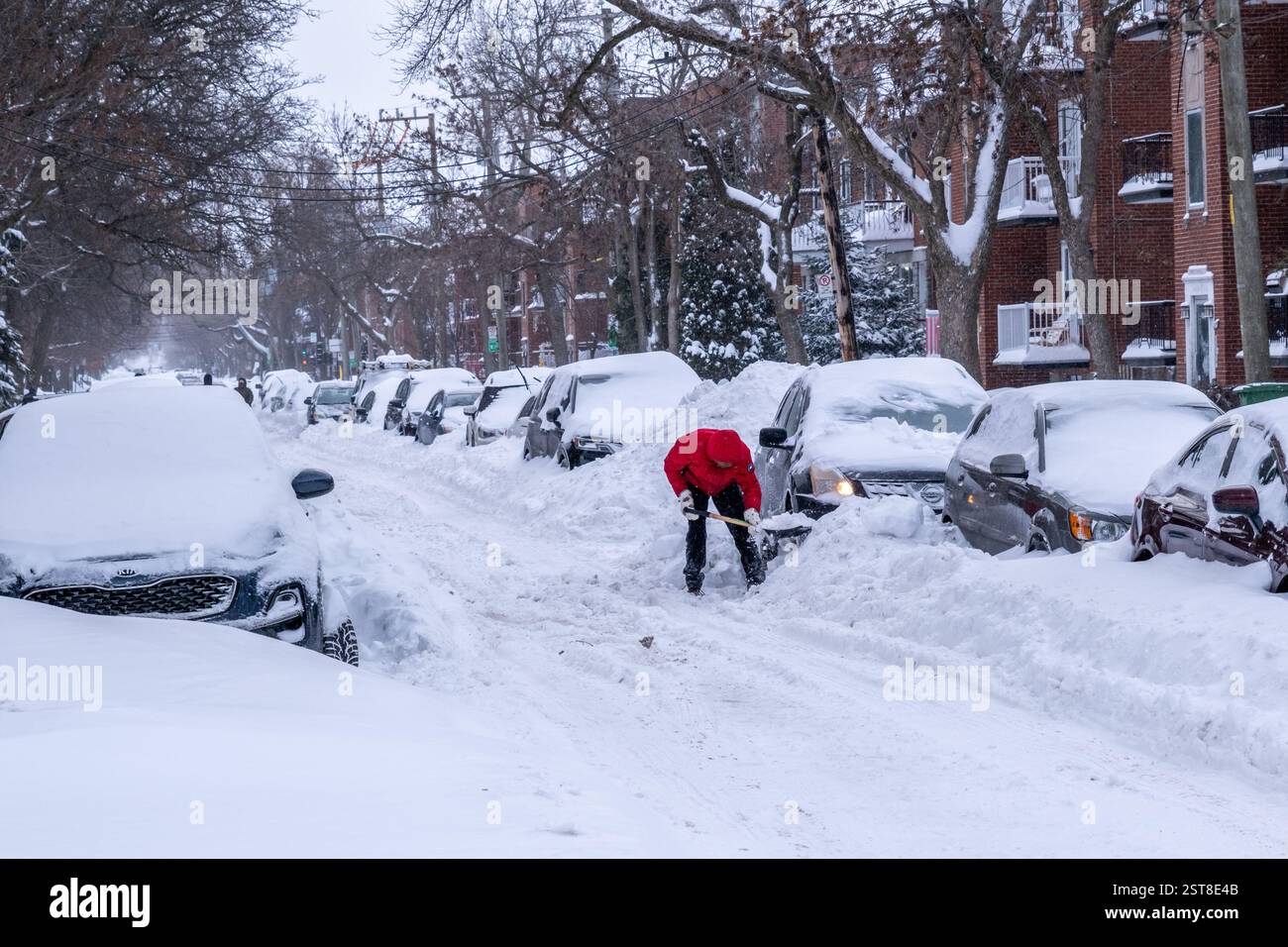 Montreal, Canada - 17 febbraio 2025: Un uomo spara la neve per liberare la sua auto dopo un'importante tempesta invernale Foto Stock