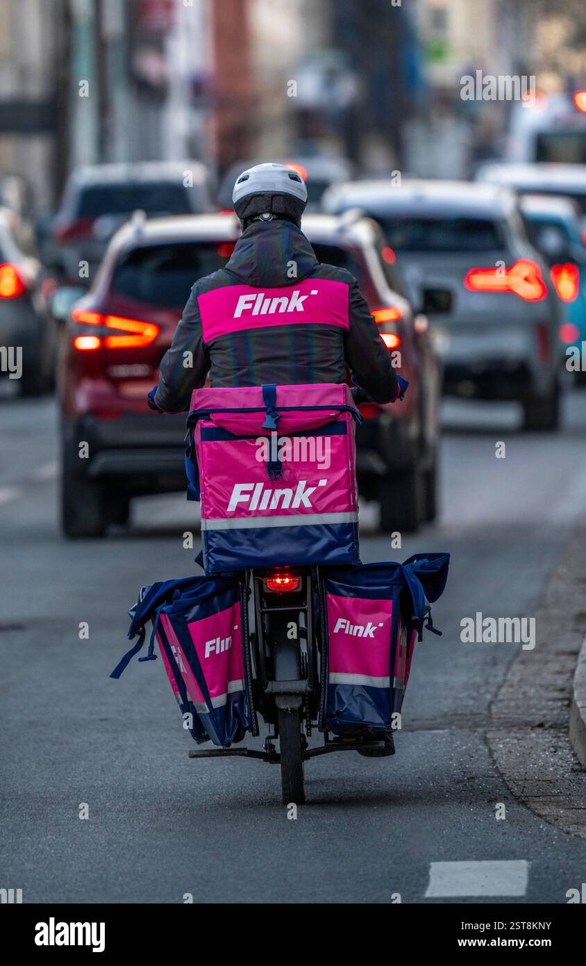 Corriere per il servizio di consegna espresso Flink, consegna cibo in oltre 40 città tedesche al momento, entro 10 minuti, ordini tramite app, funziona Foto Stock Corriere per il servizio di consegna espresso Flink, consegna cibo in oltre 40 città tedesche al momento, entro 10 minuti, ordini tramite app, funziona Foto Stock
