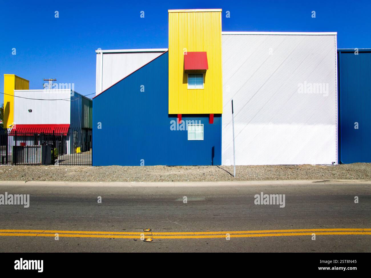 Edificio industriale colorato caratterizzato da forme geometriche sorprendenti e forti colori primari, che creano un paesaggio urbano ispirato alla pop art come Pierre mondrian Foto Stock