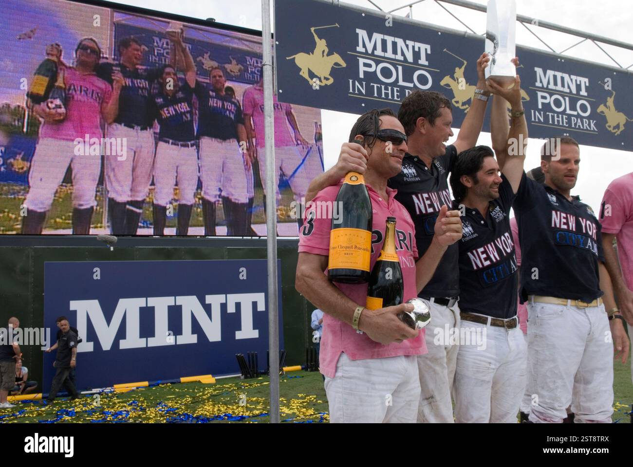 Mint Polo nel parco. Hurlingham Park Fulham Londra Regno Unito 6 giugno 2010. City AM Team New York (blu) festeggia come la squadra vincente. L'IG Index Team Paris (rosa) ha perso ma tutti hanno ancora lo champagne Veuve Clicquot., che sponsorizzava la partita di polo. 2010 UK HOMER SYKES Foto Stock