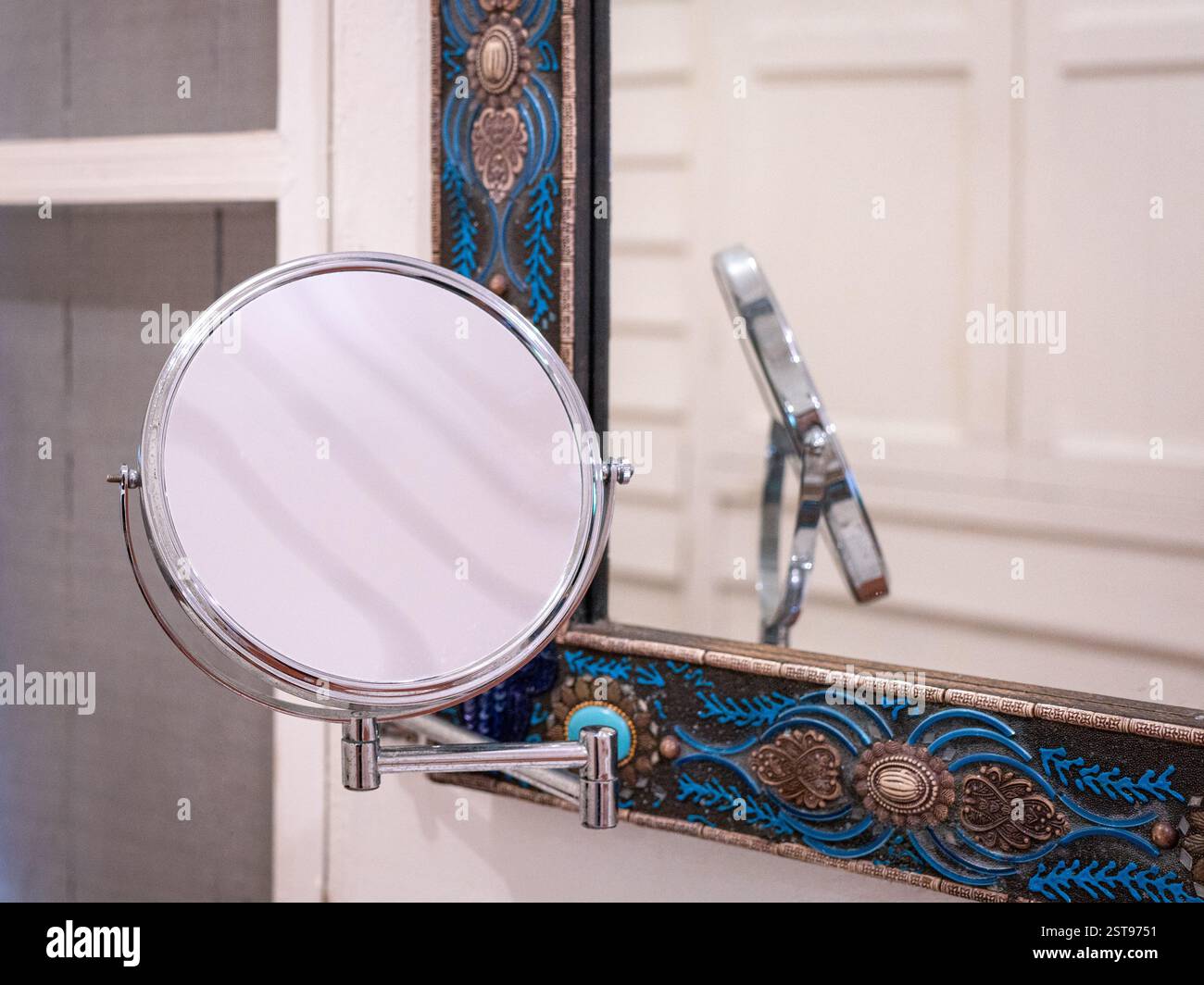 Specchio per il trucco montato a parete in bagno, accanto a uno specchio a parete. Foto Stock