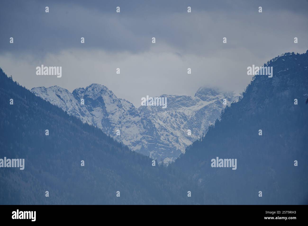 Vette innevate sotto un cielo nuvoloso, Ainring, alta Baviera Foto Stock