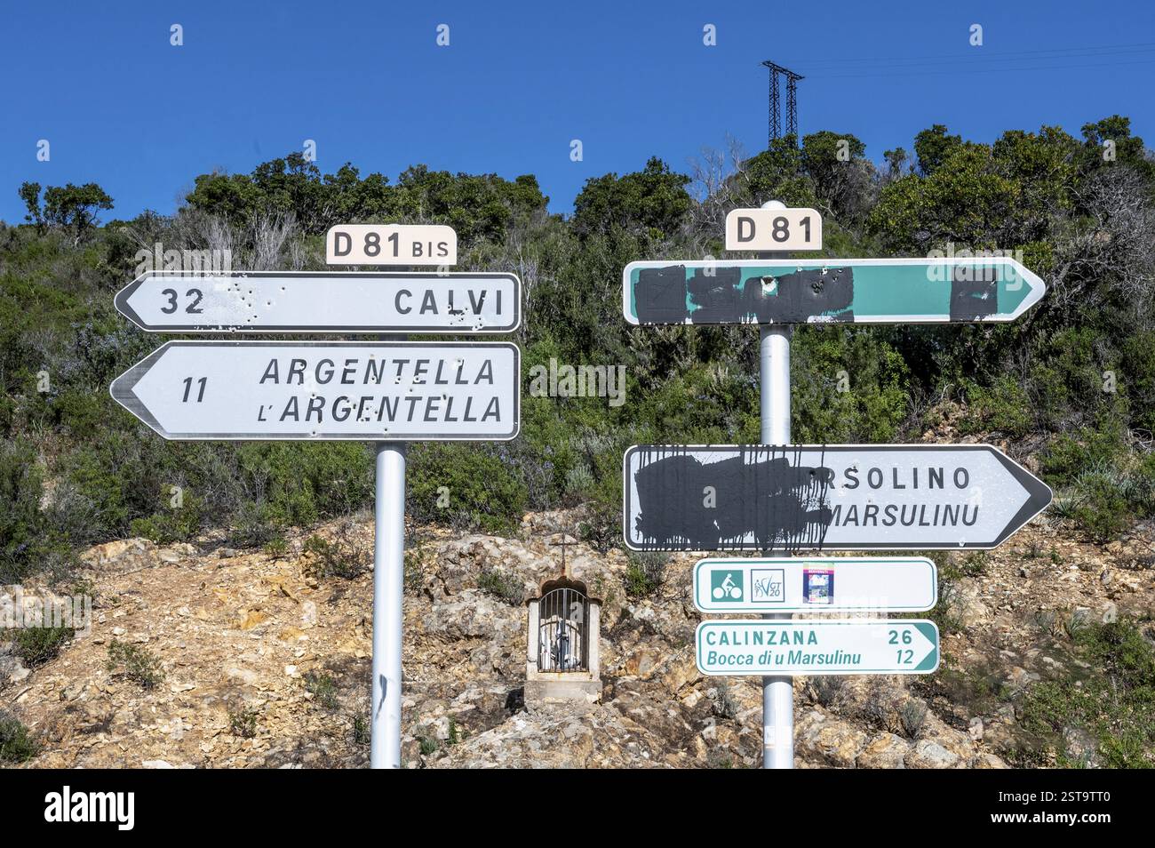 Cartelli stradali lungo il fiume fango, il Tor tor per Balagne, con numerose buche di proiettile in Corsica, protesta contro la Francia e simbolo della lotta della Corsica Foto Stock