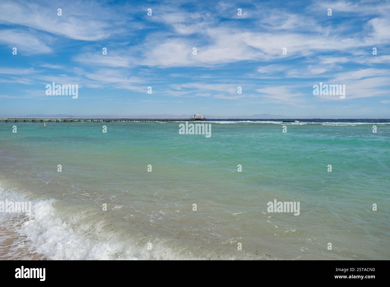 Splendide acque turchesi e una tranquilla spiaggia in Egitto sotto un cielo vibrante Foto Stock