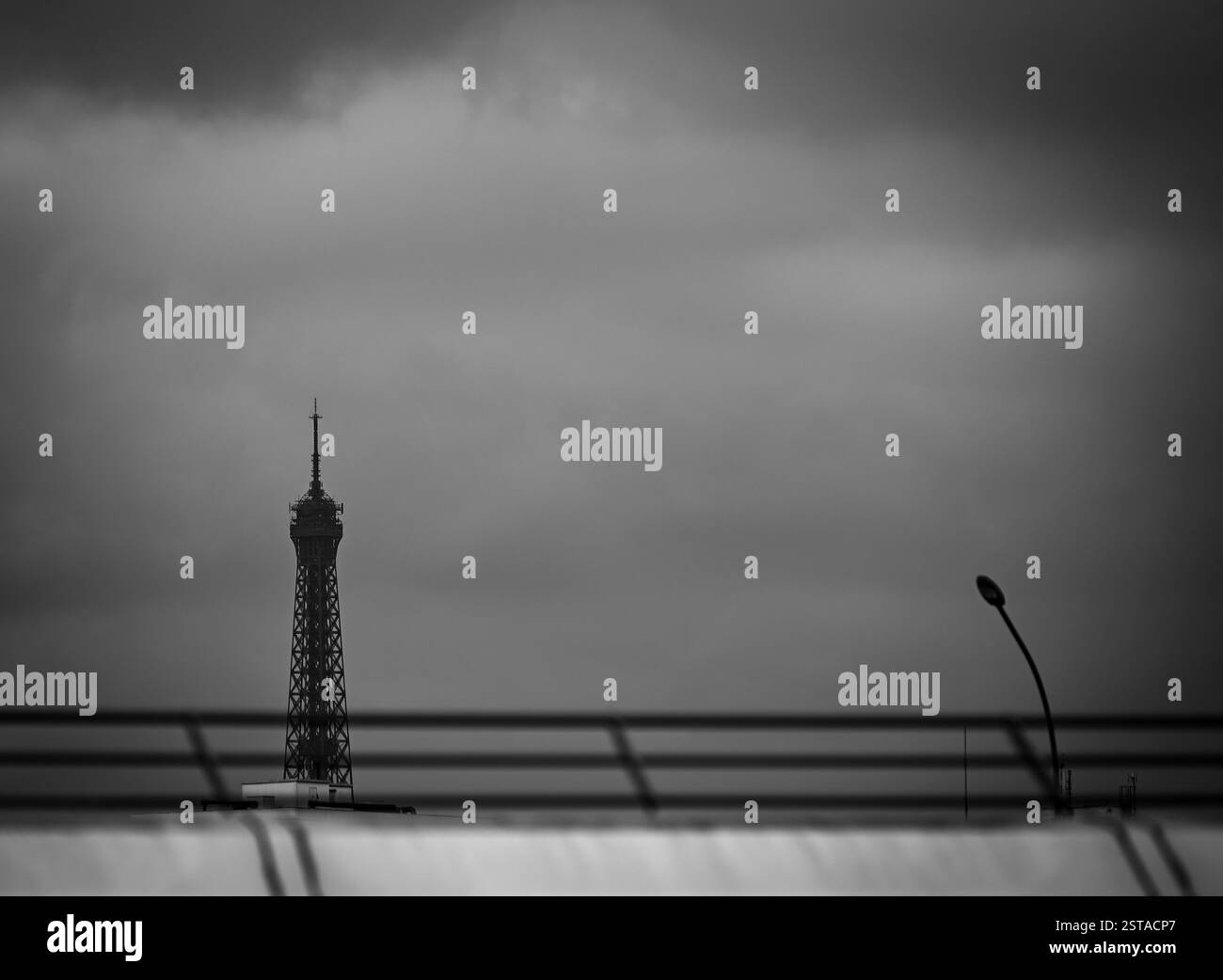 Torreggiante sopra lo skyline di Parigi, la Torre Eiffel si erge maestosamente contro un cielo lunare durante una giornata nuvolosa Foto Stock