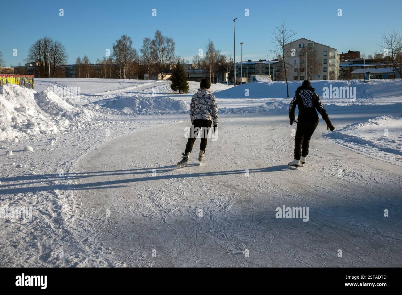 Due donne pattinano su ghiaccio in una pista all'aperto, Oulu Finlandia Foto Stock