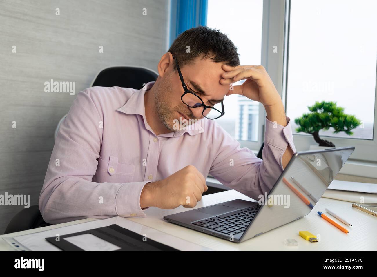 Uomo d'affari ufficio che lavora tenendo mal di testa dolore dalla scrivania di lavoro e di seduta tutto il giorno utilizzando computer portatile che soffrono mal di testa lavoratore malato overworki Foto Stock
