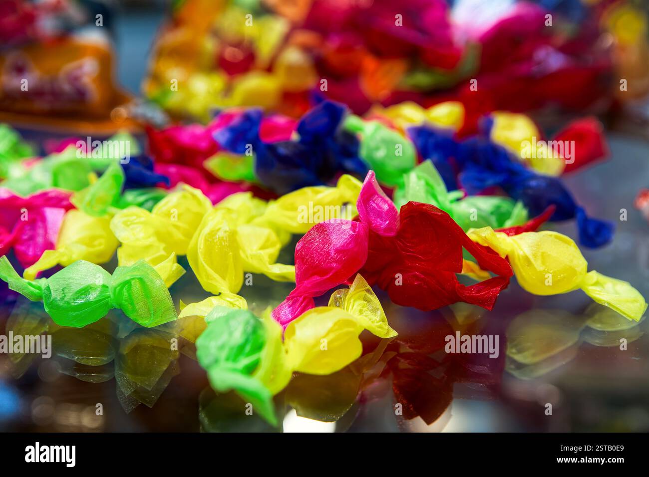 Caramelle colorate in involucri multicolore, messa a fuoco selettiva. Foto Stock