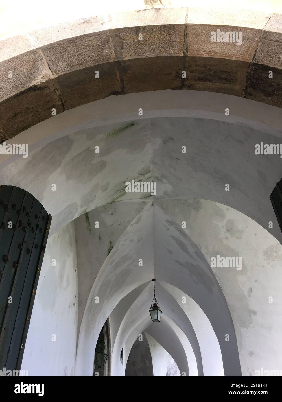 Soffitto ad arco in pietra con dettagli intricati. Sintra, Portogallo. Intonaco bianco con macchie scure e vernice sbucciante. Stile architettonico gotico. Simbolo di Foto Stock