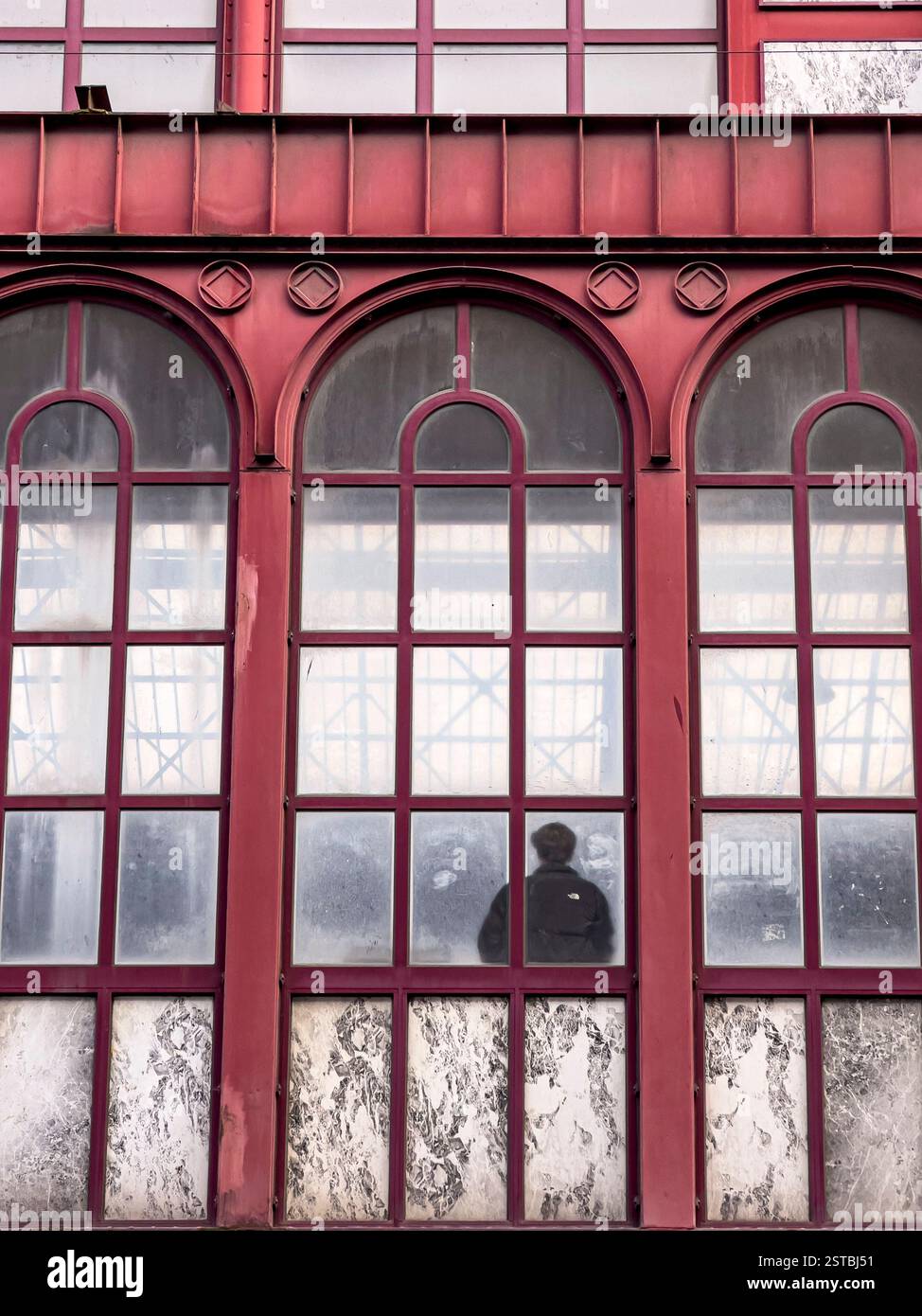 Una figura solitaria in attesa di un treno nella magnifica stazione ferroviaria principale di Anversa (Anversa-Centraal) costruita nel 1895 Foto Stock