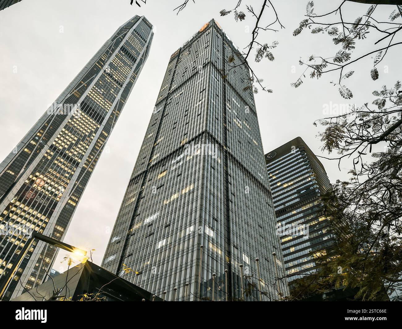 Shenzhen, Cina - 12 febbraio 2025: I moderni grattacieli di Shenzhen, Cina, si innalzano verso un cielo nuvoloso, catturati da un angolo basso. Paesaggio urbano fe Foto Stock