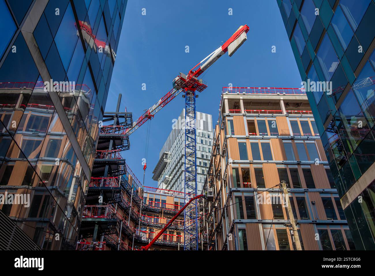Vista ad angolo basso di un cantiere con gru. Concetti di industria edile, mercato immobiliare e norme tecniche per i nuovi edifici Foto Stock