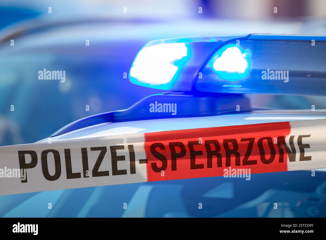 (Fotomontaggio) immagine simbolo di un'operazione di polizia: Nastro barriera con la scritta POLIZEI SPERRZONE davanti a un veicolo di emergenza Foto Stock (Fotomontaggio) immagine simbolo di un'operazione di polizia: Nastro barriera con la scritta POLIZEI SPERRZONE davanti a un veicolo di emergenza Foto Stock