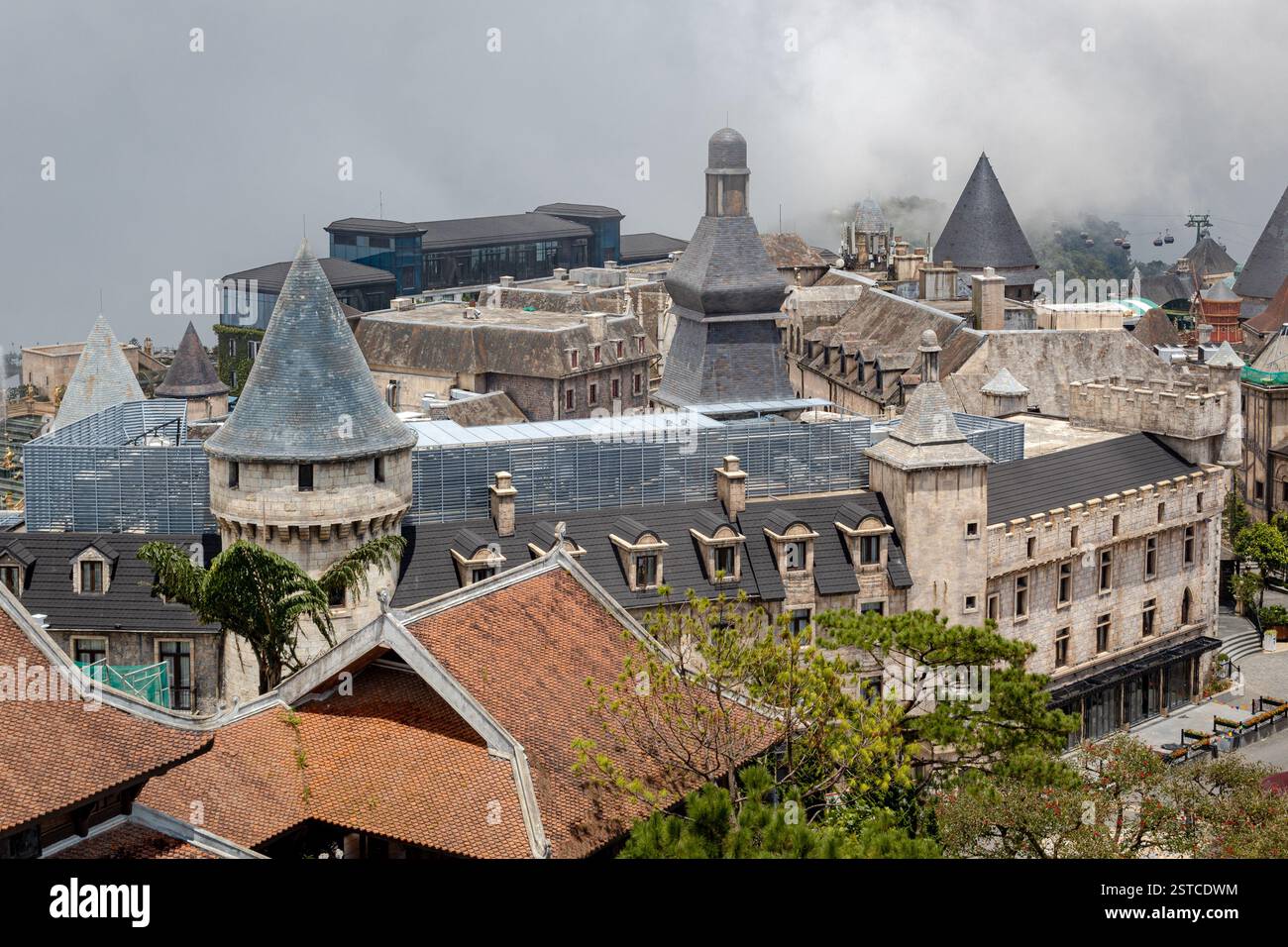 Edifici francesi di ispirazione europea presso il parco divertimenti Ba Na Hills Sunworld a Danang in Vietnam in una giornata nebbiosa e nuvolosa Foto Stock