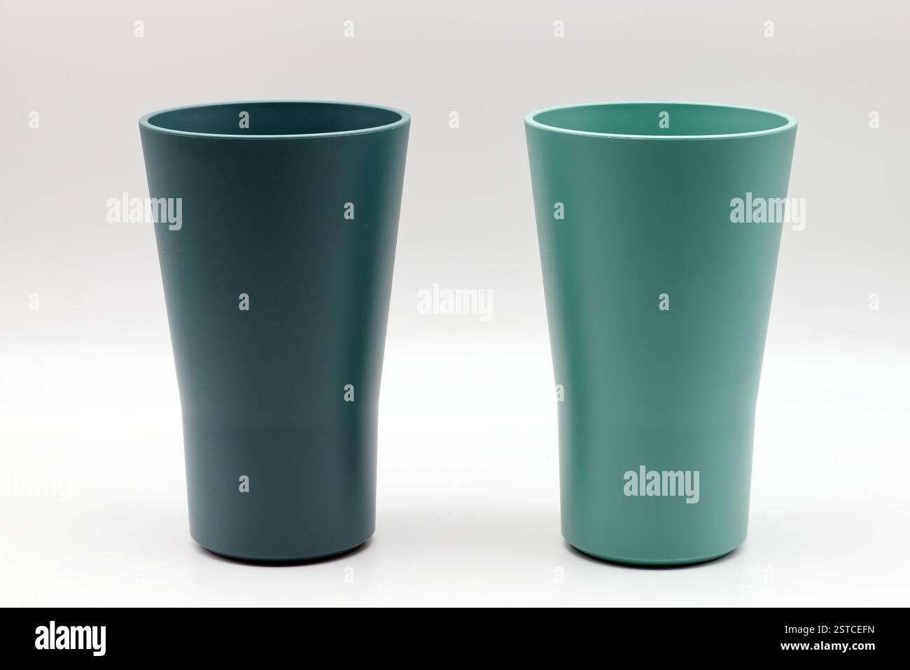 Due moderne tazze di plastica verde menta e tè isolate su sfondo bianco Foto Stock
