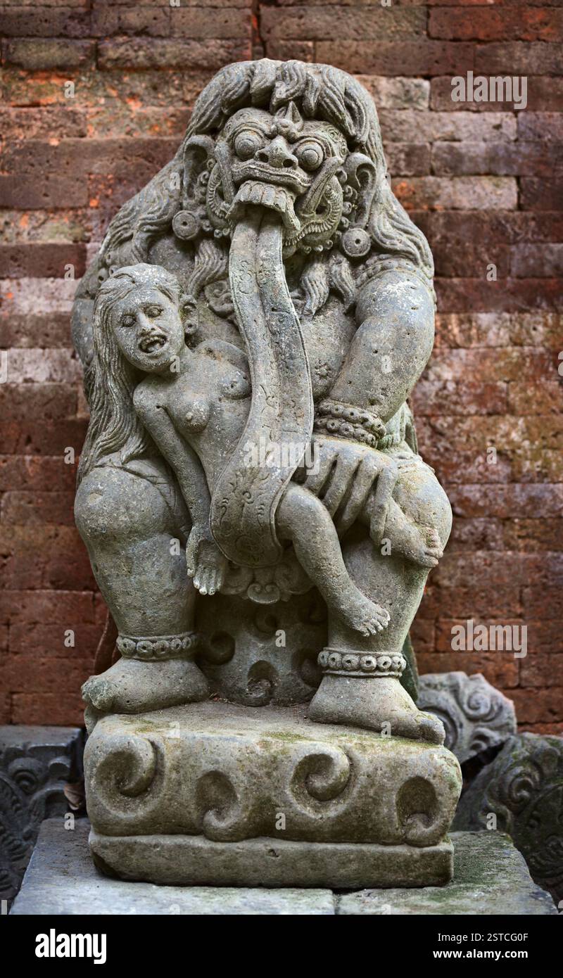 Antica statua di Rangda che mangia bambini. Indonesia, Bali. Foto Stock