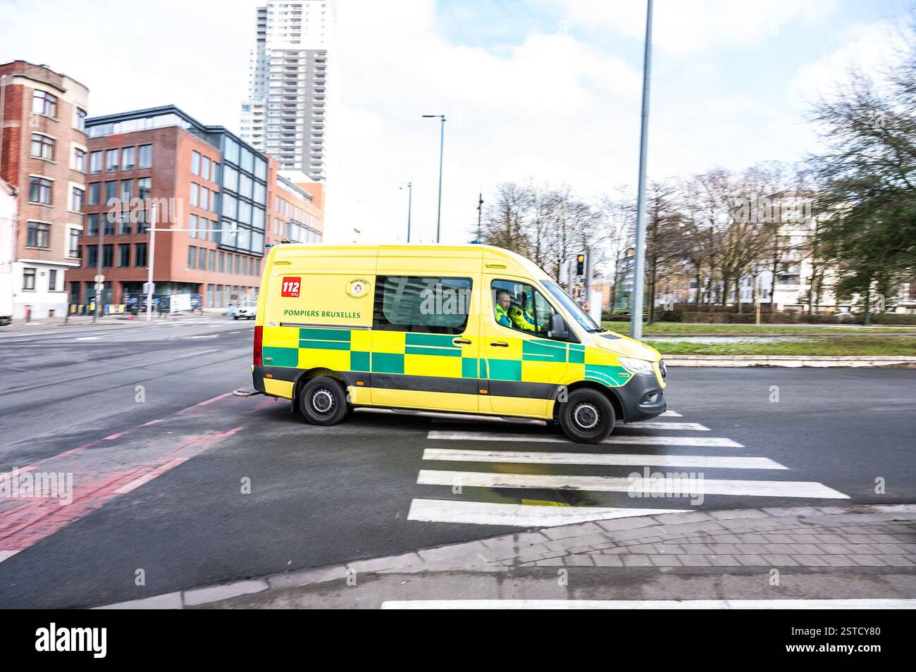 Ambulanza gialla che guida per le strade per una chiamata di emergenza a Bruxelles, Belgio, 16 FEB, 2025 Foto Stock