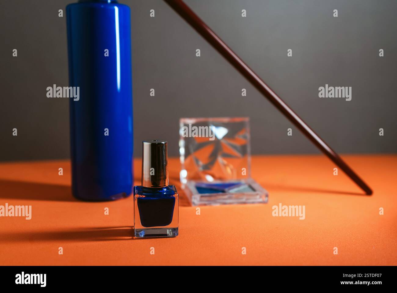 Forniture d'arte blu vibranti disposte su una superficie arancione brillante che crea un contrasto sorprendente nei colori. Foto Stock