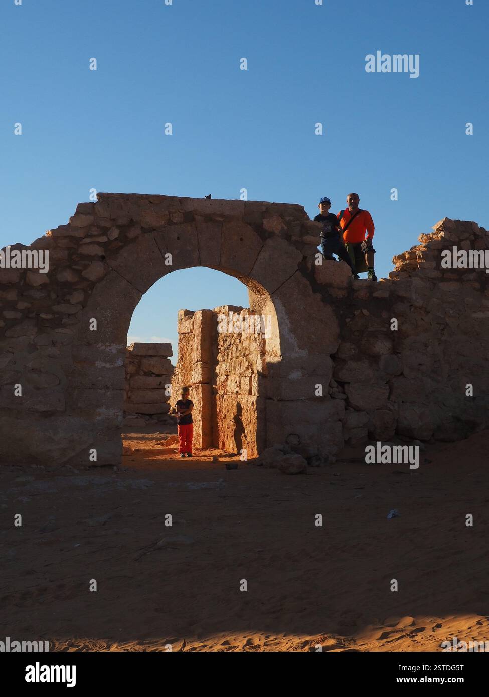 Padre e figlio seduti sulle rovine di un forte militare nel deserto del Sahara in Tunisia Foto Stock